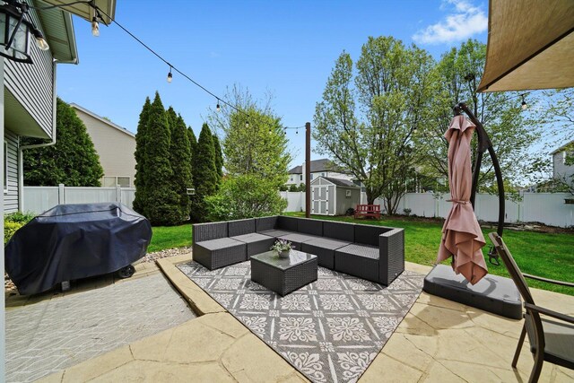 view of patio featuring an outdoor structure, grilling area, a fenced backyard, a shed, and an outdoor hangout area