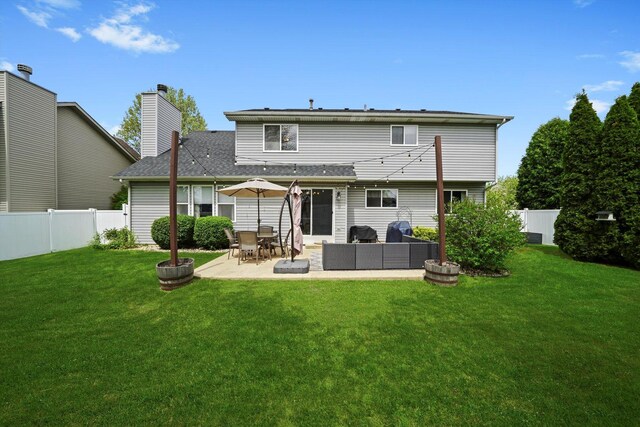 rear view of house featuring outdoor lounge area, a patio, a fenced backyard, a chimney, and a yard