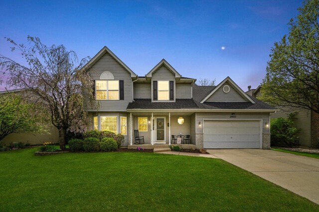 traditional-style house with roof with shingles, a front lawn, a garage, a porch, and concrete driveway