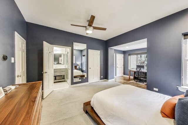 bedroom with carpet floors, a ceiling fan, baseboards, and ensuite bath