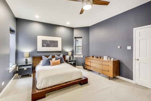 bedroom with baseboards, a ceiling fan, and light carpet