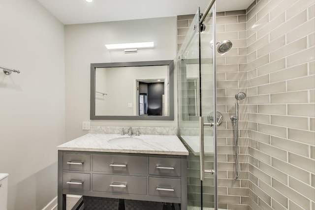 bathroom with vanity, a shower stall, and toilet