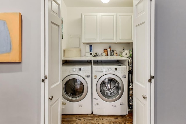 laundry area with cabinet space, washing machine and dryer, and dark wood-type flooring