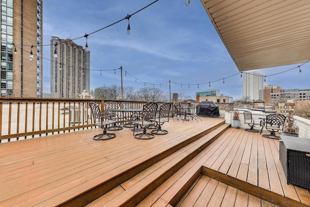 deck featuring a city view and outdoor dining area