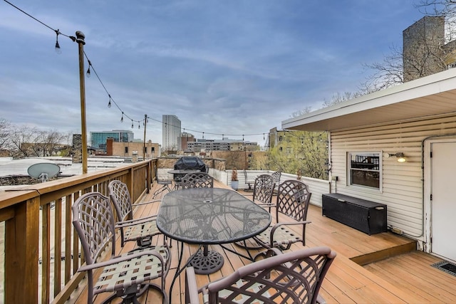 wooden deck featuring visible vents and outdoor dining area