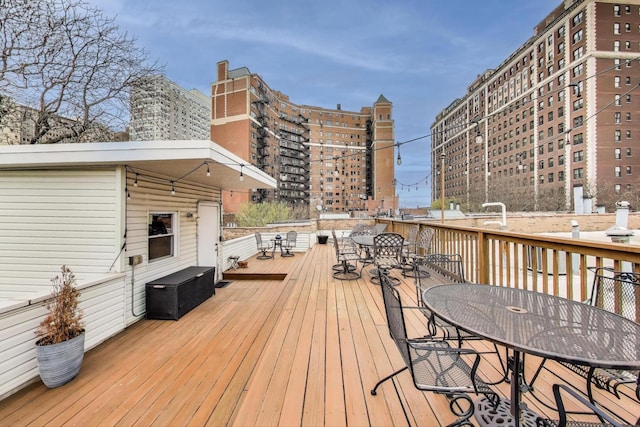 wooden terrace featuring a view of city and outdoor dining area