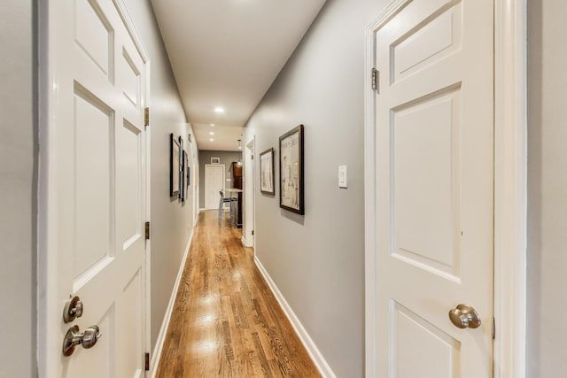 corridor with recessed lighting, baseboards, and light wood-style flooring