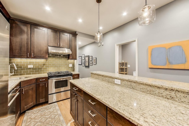 kitchen featuring a sink, light wood-style flooring, tasteful backsplash, and stainless steel appliances