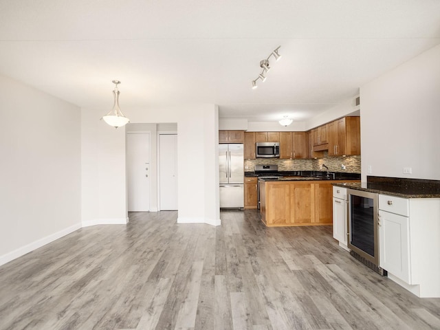 kitchen with light wood-style flooring, stainless steel appliances, decorative backsplash, wine cooler, and pendant lighting
