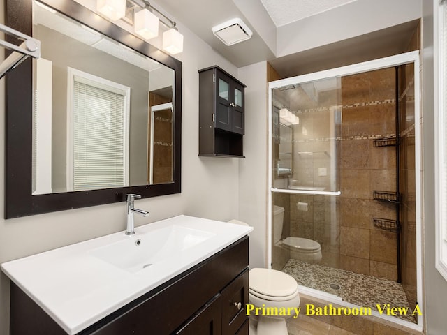 bathroom with vanity, toilet, and a stall shower