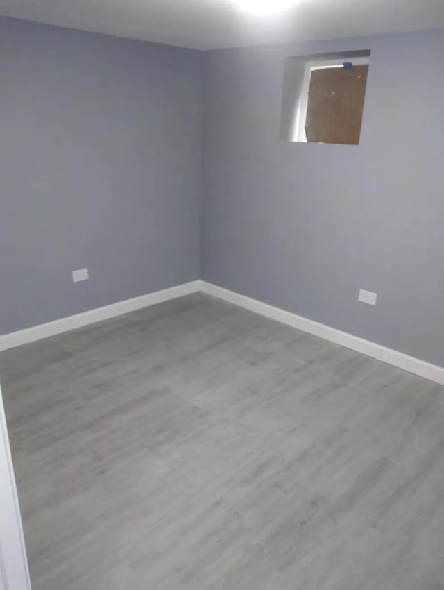 empty room with baseboards and wood finished floors