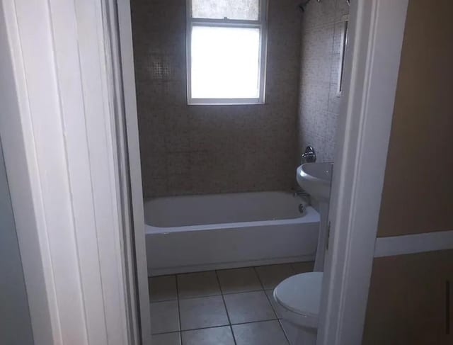 bathroom featuring tile patterned flooring, shower / bathing tub combination, and toilet
