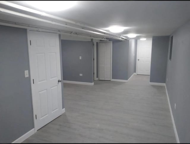 finished basement featuring baseboards and light wood-style floors