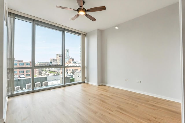 125 S Green St Unit 1007A, Chicago, IL 60607 - empty room with a city view, healthy amount of natural light, light wood-style flooring, a ceiling fan, and expansive windows