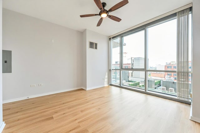 125 S Green St Unit 1007A, Chicago, IL 60607 - empty room with electric panel, floor to ceiling windows, light wood-type flooring, a ceiling fan, and baseboards