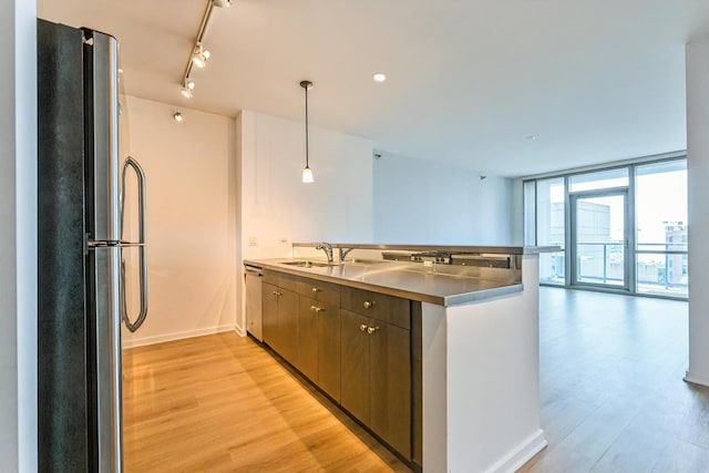 125 S Green St Unit 1007A, Chicago, IL 60607 - kitchen featuring stainless steel appliances, a sink, light wood-style flooring, baseboards, and a peninsula