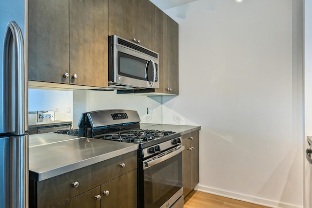 125 S Green St Unit 1007A, Chicago, IL 60607 - kitchen with stainless steel appliances, stainless steel countertops, light wood-type flooring, and dark brown cabinets