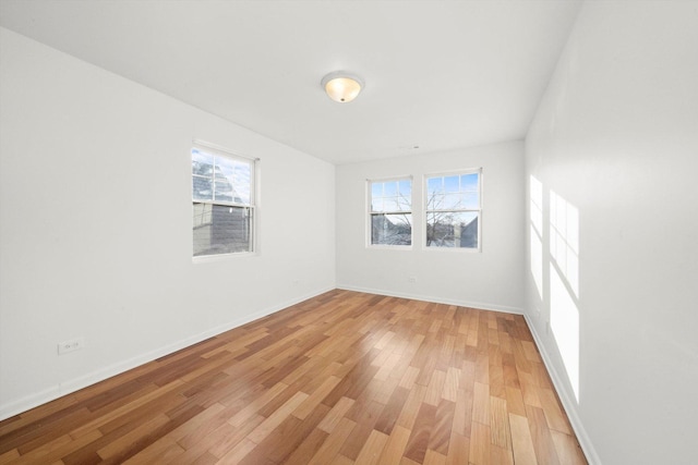 empty room with baseboards and light wood-style floors