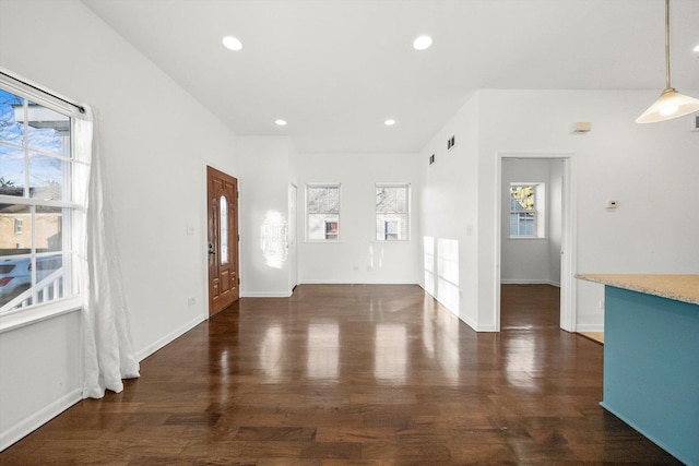 interior space with baseboards, dark wood finished floors, a healthy amount of sunlight, and visible vents