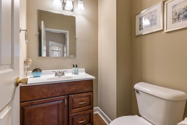half bathroom featuring vanity and toilet