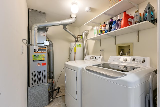 clothes washing area featuring laundry area, washer and clothes dryer, and water heater