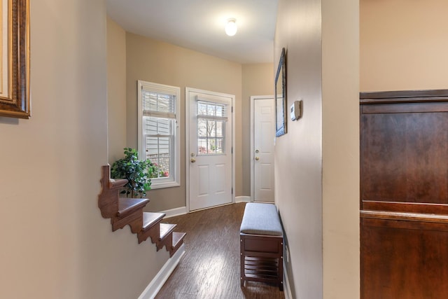 doorway with baseboards, dark wood finished floors, and stairway
