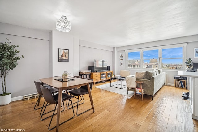 dining area with baseboards and light wood finished floors
