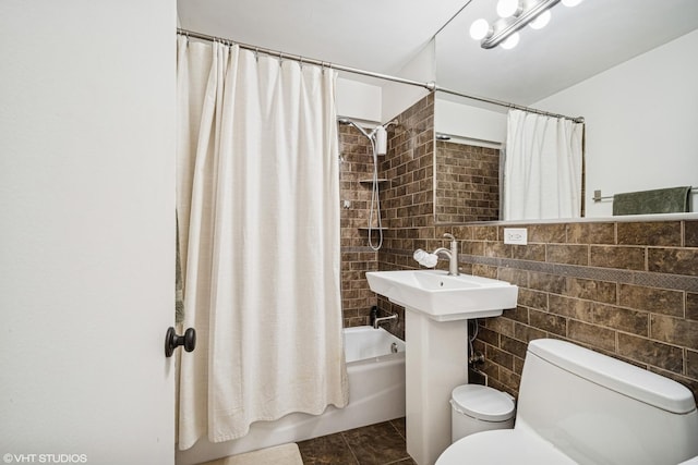 bathroom with tile patterned floors, shower / bath combo, toilet, and tile walls