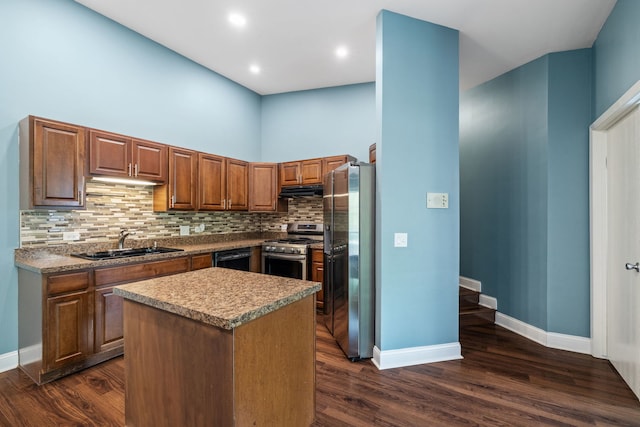 kitchen featuring baseboards, a center island, a sink, appliances with stainless steel finishes, and backsplash