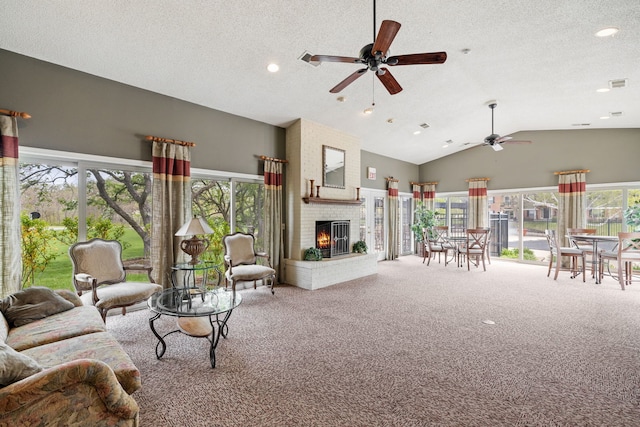 carpeted living area with plenty of natural light, a ceiling fan, a fireplace, and high vaulted ceiling