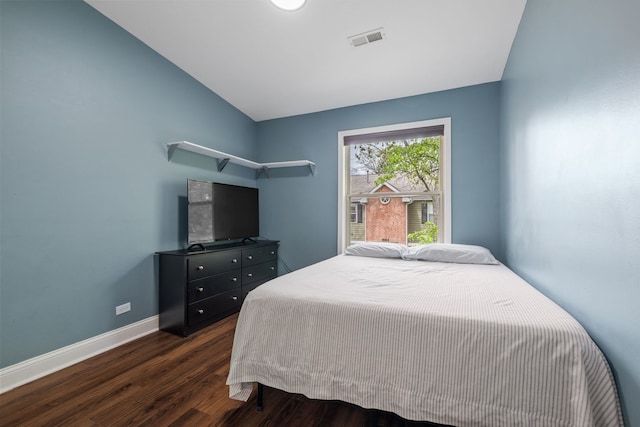 bedroom featuring baseboards, visible vents, dark wood-style floors, and vaulted ceiling