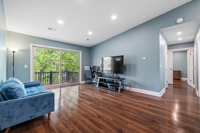 living area featuring baseboards, visible vents, and wood finished floors