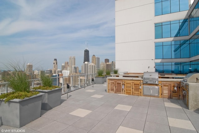 view of patio / terrace featuring grilling area, exterior kitchen, and a city view