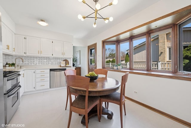 dining area featuring baseboards, light floors, a chandelier, and a wealth of natural light
