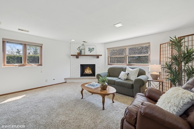 carpeted living area featuring baseboards, a brick fireplace, and visible vents