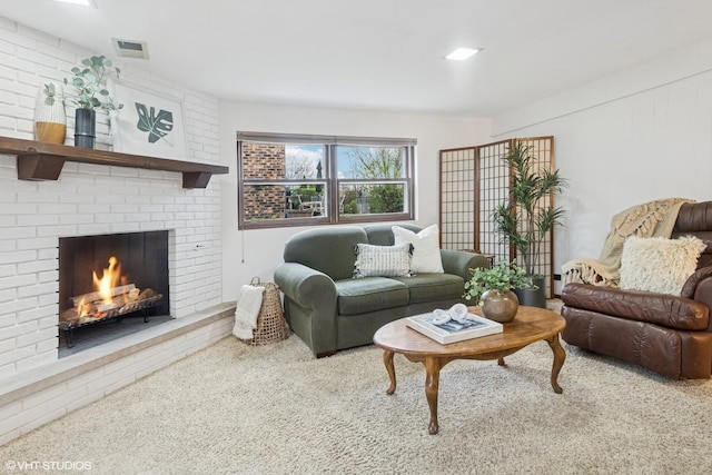 carpeted living area with visible vents and a brick fireplace