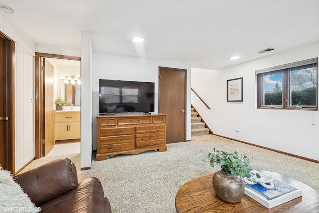 living room with stairway, visible vents, baseboards, and carpet