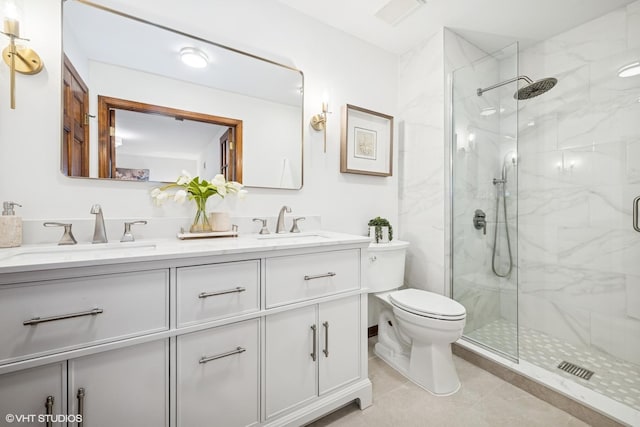 bathroom with a sink, a marble finish shower, toilet, and double vanity