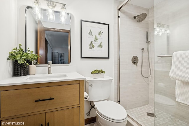 full bathroom featuring toilet, tiled shower, and vanity