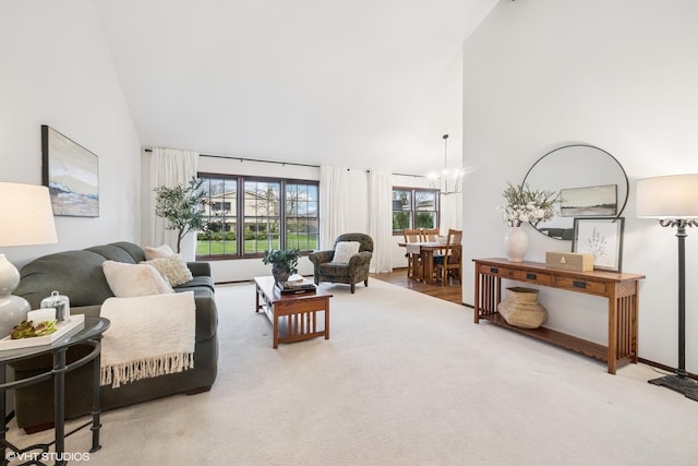 carpeted living room with a chandelier and high vaulted ceiling