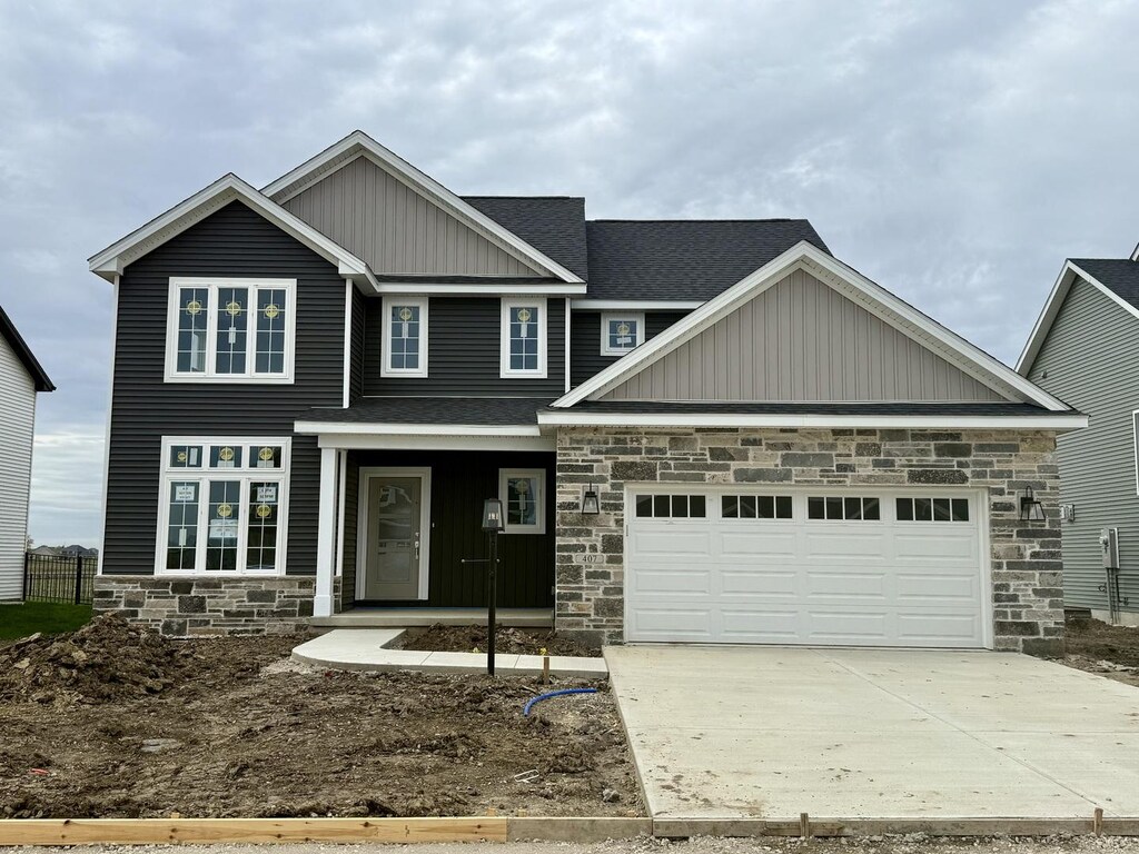 craftsman inspired home featuring board and batten siding, driveway, an attached garage, a shingled roof, and stone siding
