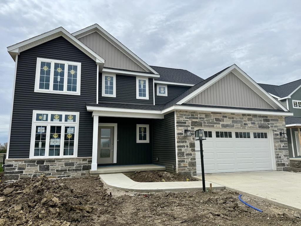 craftsman inspired home featuring concrete driveway, board and batten siding, an attached garage, and stone siding