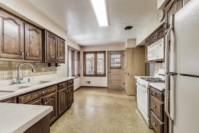 621 N Hamlin Ave, Park Ridge, IL 60068 - kitchen featuring dark brown cabinetry, a sink, light countertops, light floors, and white appliances
