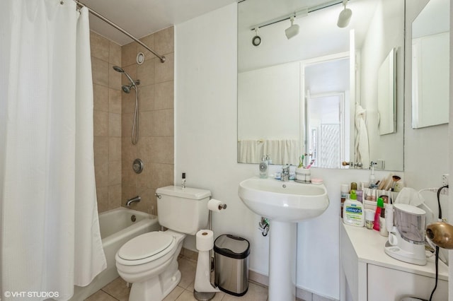 bathroom featuring a sink, tile patterned floors, toilet, and shower / bath combination with curtain