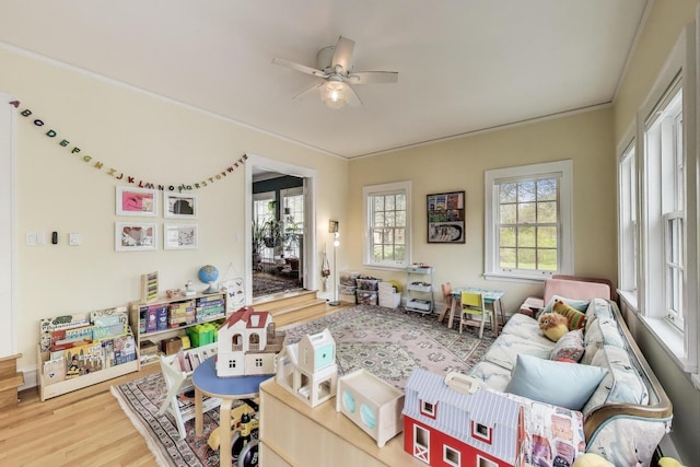 rec room featuring healthy amount of natural light, a ceiling fan, and wood finished floors