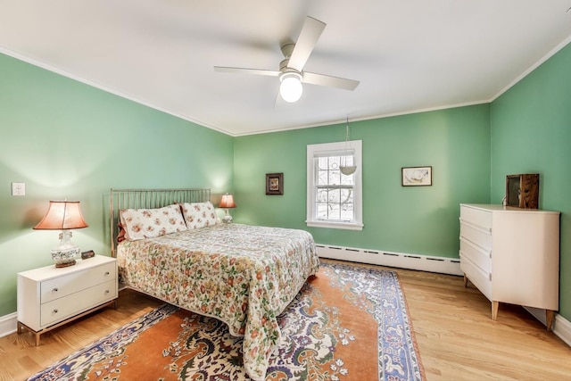 bedroom with baseboard heating, crown molding, wood finished floors, ceiling fan, and baseboards