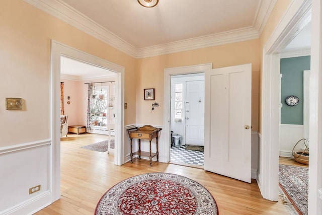 foyer entrance featuring crown molding and light wood-style floors