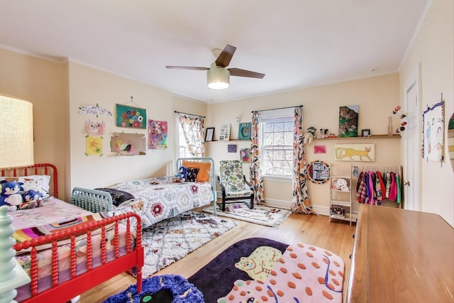 bedroom with wood finished floors, a ceiling fan, and crown molding