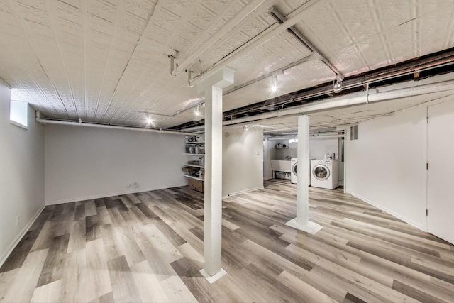 finished below grade area featuring washer / clothes dryer, light wood-type flooring, and baseboards