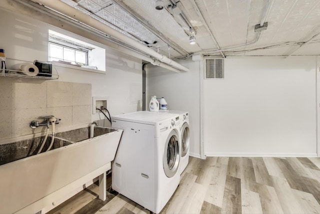 washroom with separate washer and dryer and light wood-type flooring